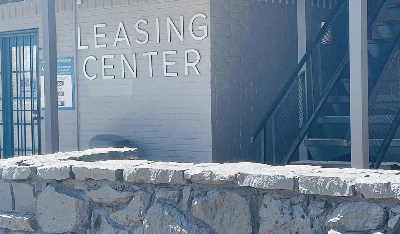 a stone wall with a sign that says leasing center at The 3311 at Vernon